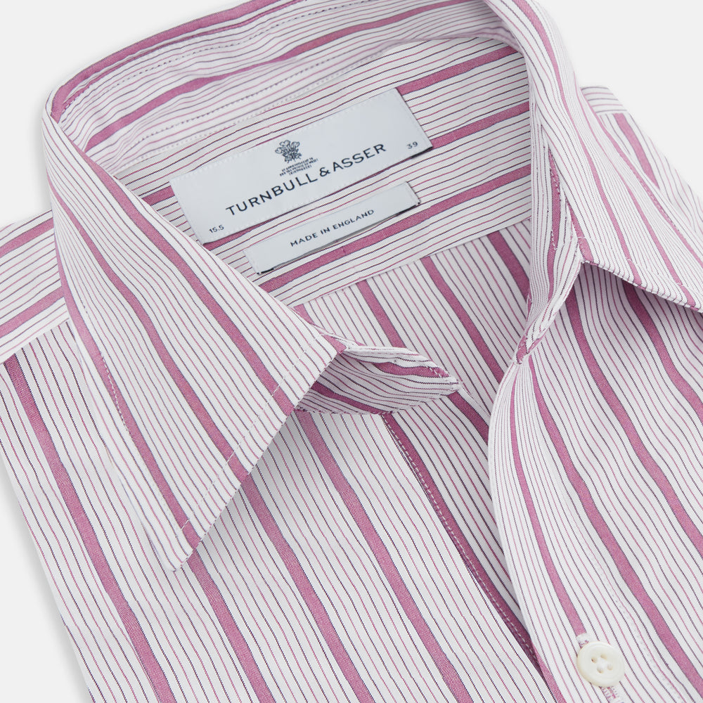 The Purple Multi Track Stripe Chelsea Shirt by Turnbull & Asser features a long-sleeve button-up design with an open Chelsea collar, purple background, vertical multi track stripes, front left pocket, and classic buttoned cuffs.