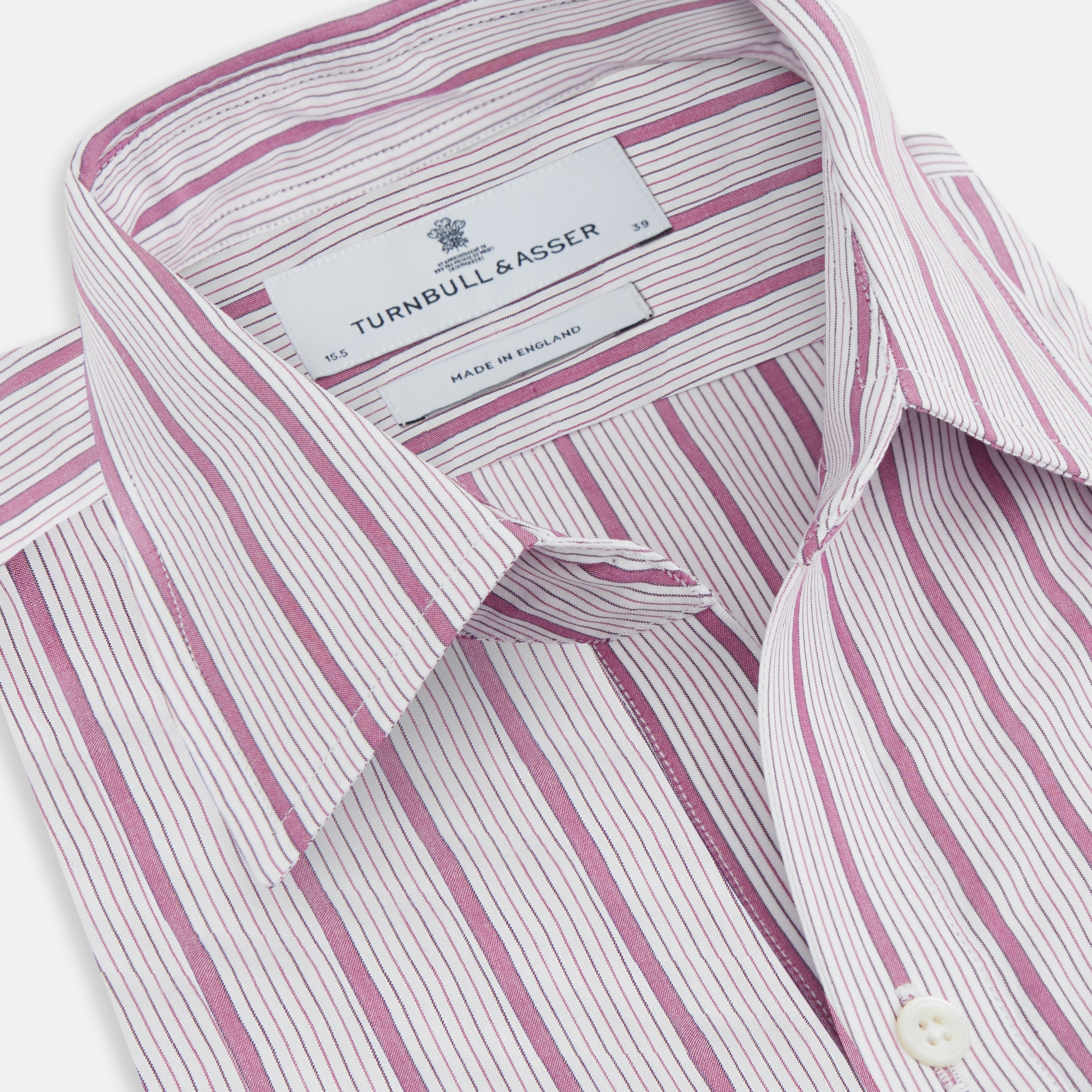 View 2 of product The Purple Multi Track Stripe Chelsea Shirt by Turnbull & Asser features a long-sleeve button-up design with an open Chelsea collar, purple background, vertical multi track stripes, front left pocket, and classic buttoned cuffs.