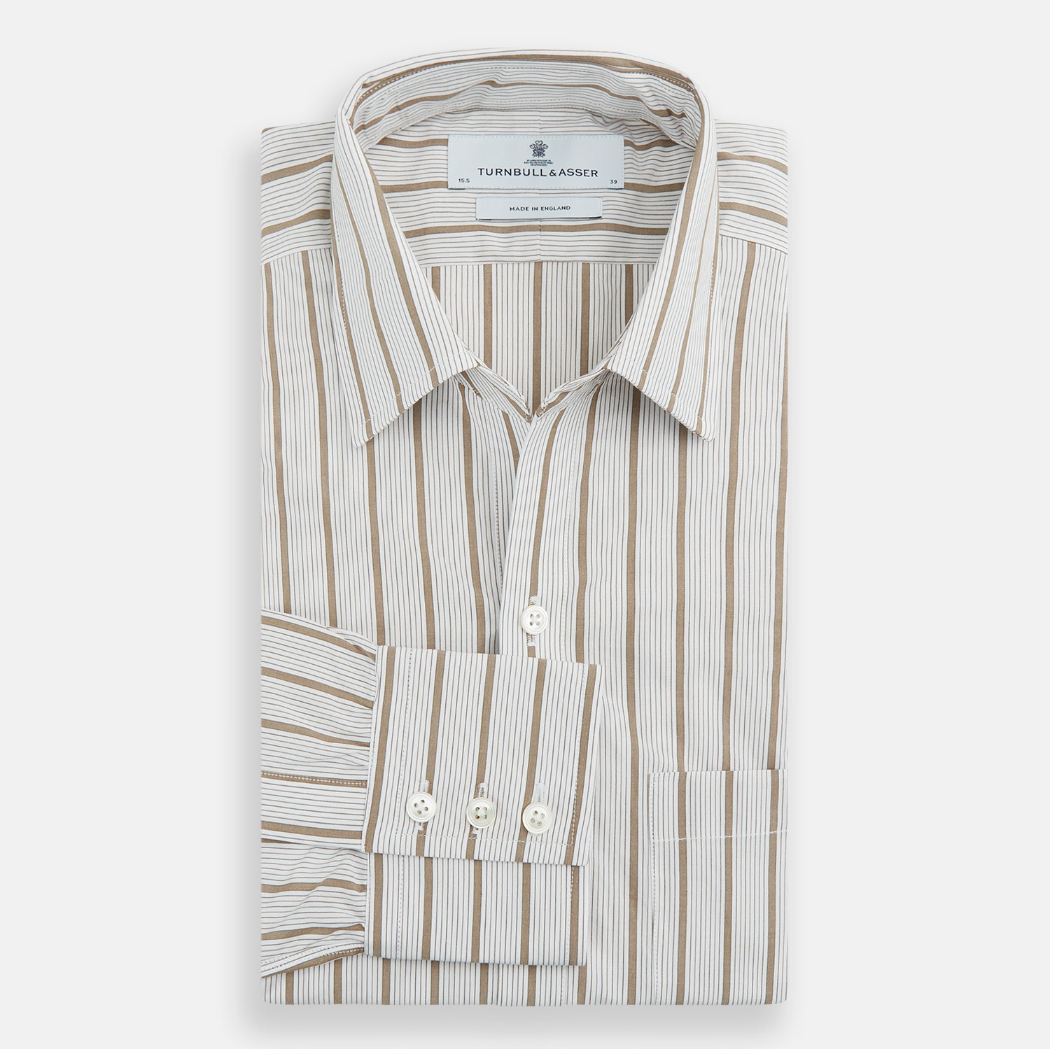 View 5 of product The Turnbull & Asser Brown Multi Track Stripe Chelsea Shirt features long sleeves, multi-track tan stripes, a left chest pocket, and an open T&A collar, shown laid flat on a white background.