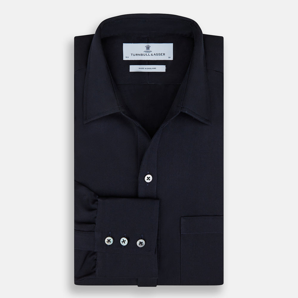 The Turnbull & Asser Navy Twill Chelsea Shirt is a long-sleeve button-up with a collar, front chest pocket, and white buttons, shown against a plain white background.
