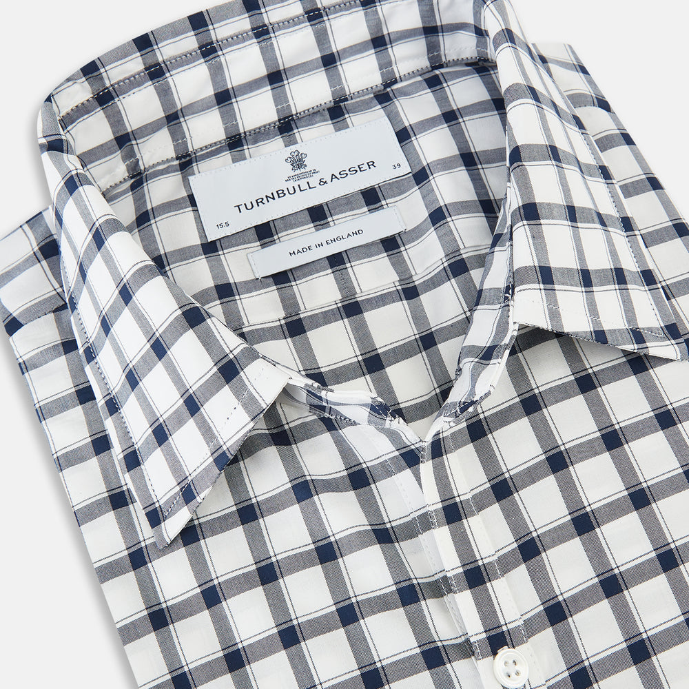 A Chequered Navy on White Windsor Regular Fit Shirt in Cotton by Turnbull & Asser UK, featuring long sleeves, a classic collar, buttoned cuffs, and a navy and white windowpane check pattern, displayed on a white background.