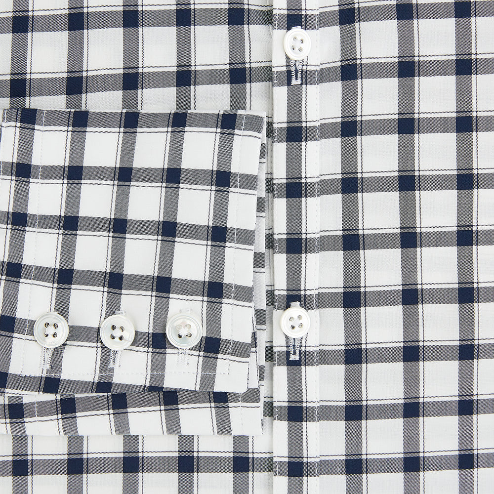 A Chequered Navy on White Windsor Regular Fit Shirt in Cotton by Turnbull & Asser UK, featuring long sleeves, a classic collar, buttoned cuffs, and a navy and white windowpane check pattern, displayed on a white background.