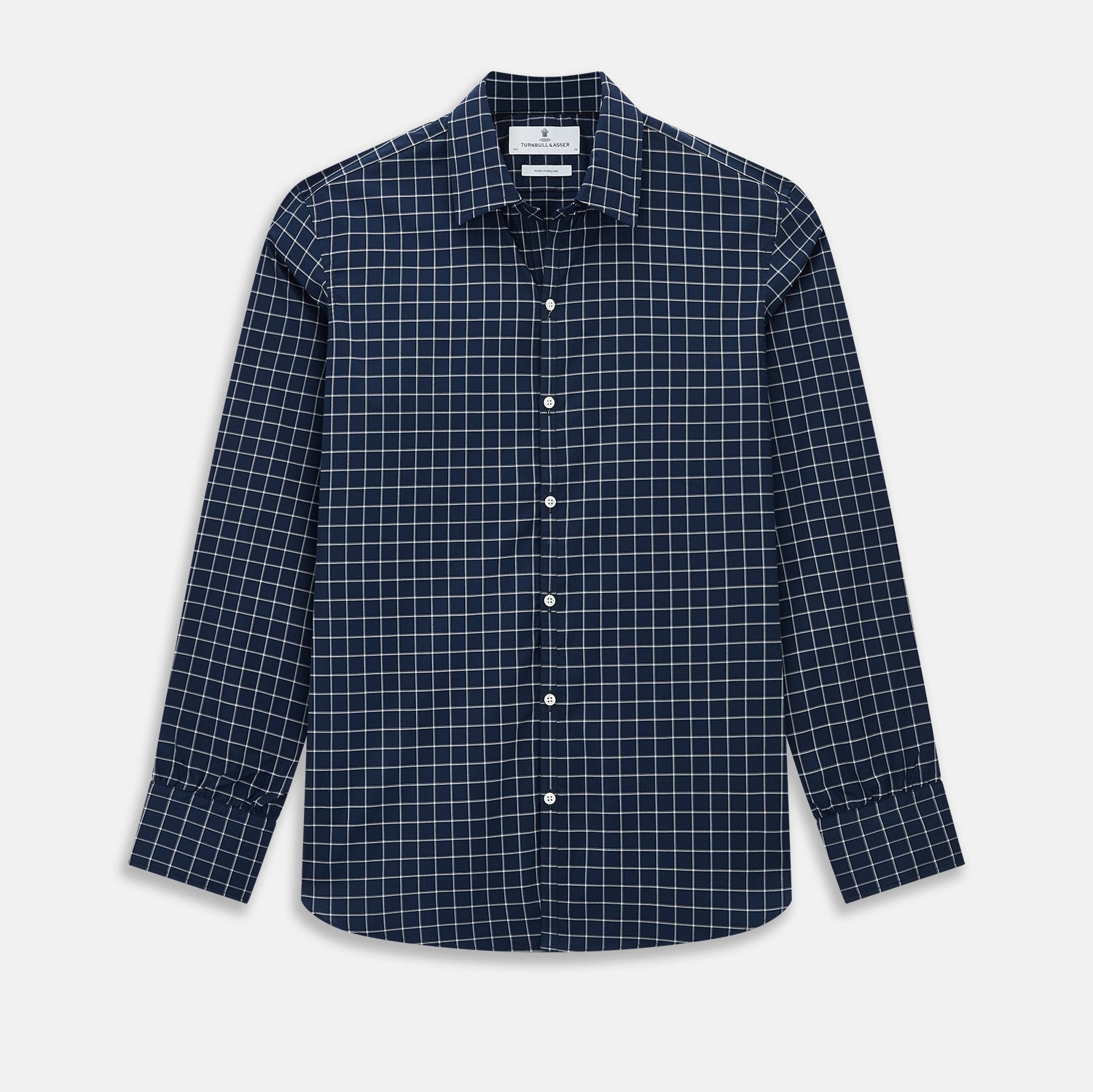 View 1 of product The Turnbull & Asser UK Windsor Navy Regular Fit Shirt in Cotton is a classic men's long-sleeve, button-up shirt featuring a navy blue base with a white grid pattern, displayed laid flat on a white background.