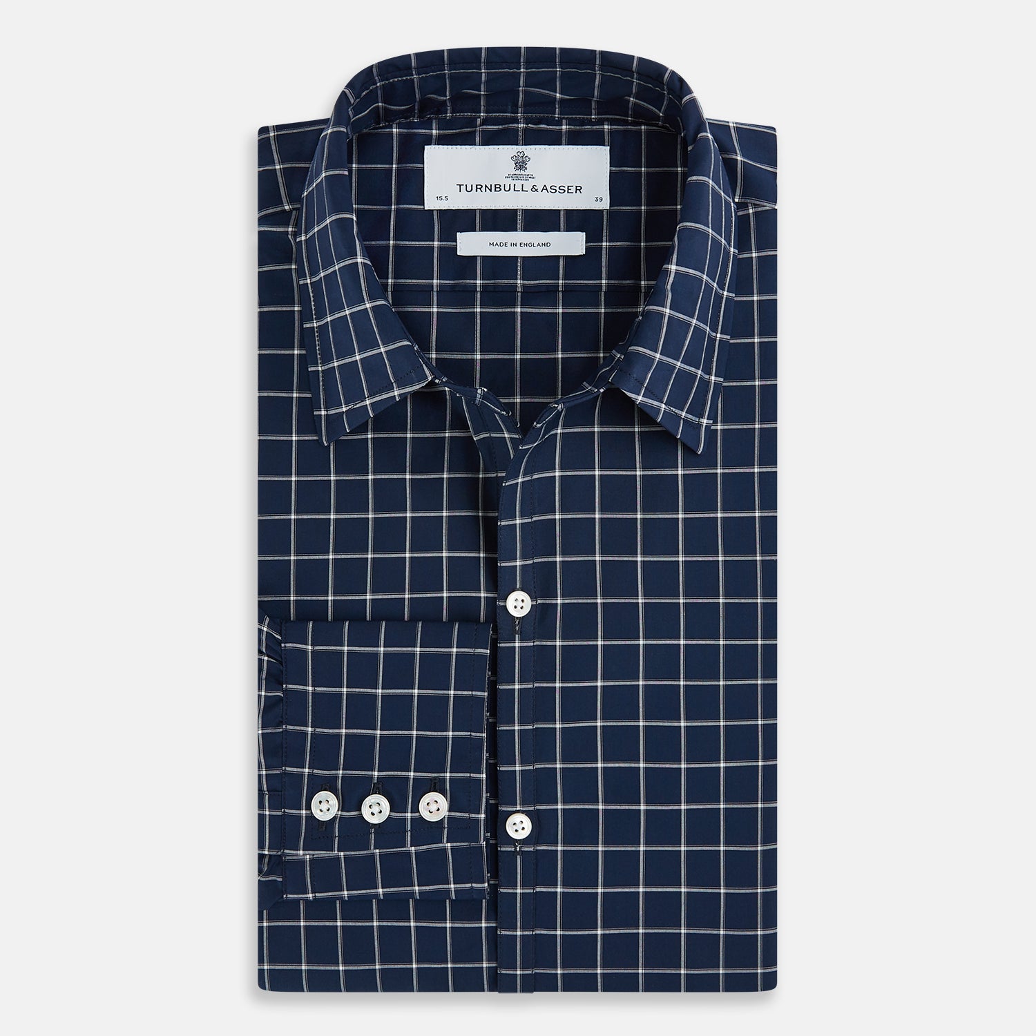 View 5 of product The Turnbull & Asser UK Windsor Navy Regular Fit Shirt in Cotton is a classic men's long-sleeve, button-up shirt featuring a navy blue base with a white grid pattern, displayed laid flat on a white background.
