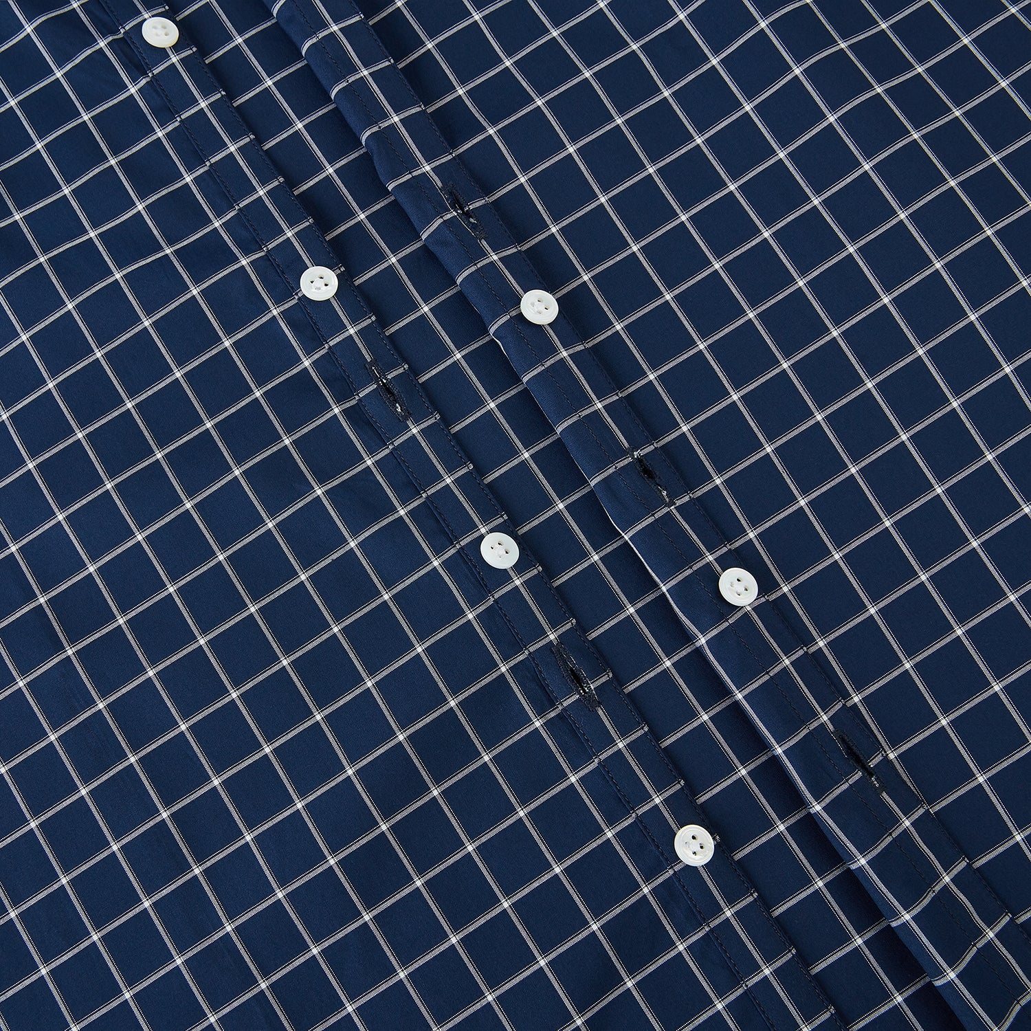 View 7 of product The Turnbull & Asser UK Windsor Navy Regular Fit Shirt in Cotton is a classic men's long-sleeve, button-up shirt featuring a navy blue base with a white grid pattern, displayed laid flat on a white background.