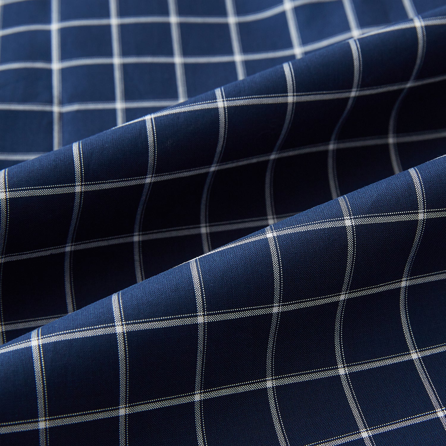 View 8 of product The Turnbull & Asser UK Windsor Navy Regular Fit Shirt in Cotton is a classic men's long-sleeve, button-up shirt featuring a navy blue base with a white grid pattern, displayed laid flat on a white background.
