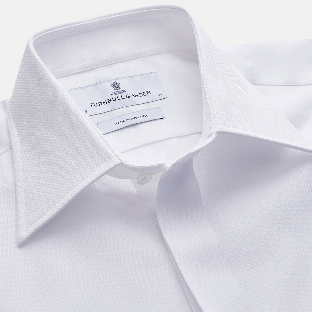The Turnbull & Asser White Tailored Fit Dress Shirt, featuring a classic collar and button cuffs, is neatly displayed against a white background—perfect as a black tie shirt for formal occasions.