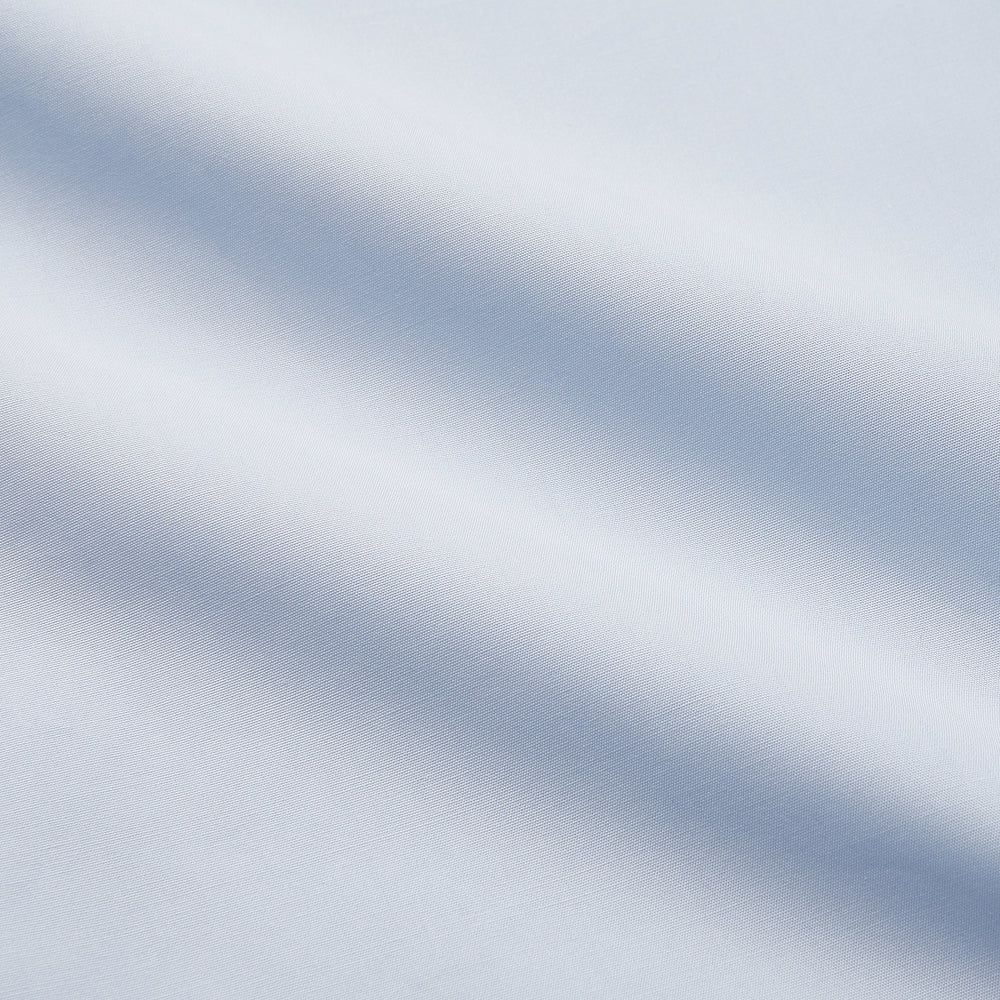 The Turnbull & Asser Tailored Fit Light Blue Cotton Shirt features a Kent collar, buttoned front, and 3-button cuffs, ideal for pairing with a navy suit and shown laid flat on a white background.