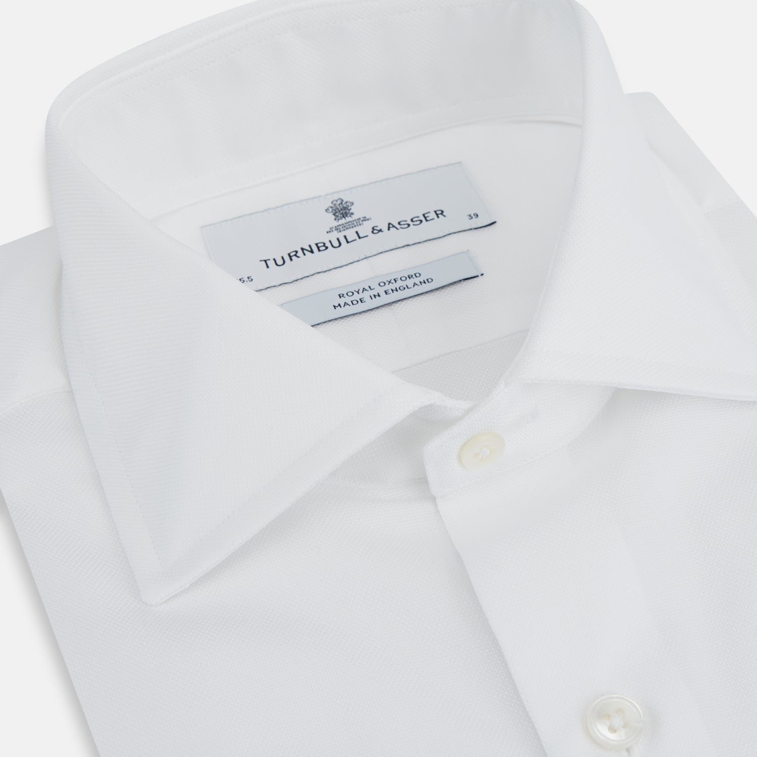 View 2 of product The Turnbull & Asser Tailored Fit White Royal Oxford Cotton Shirt features a Kent collar, double cuffs, and front buttons, shown on a clean white background.
