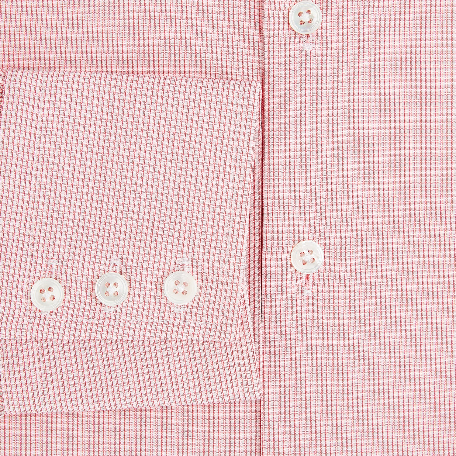 View 4 of product The Turnbull & Asser UK CORAL COTTON MINI CHECKED SHIRT is a light pink long-sleeve button-up shirt with a Kent collar, white buttons, and three-button cuffs, shown on a plain white background.