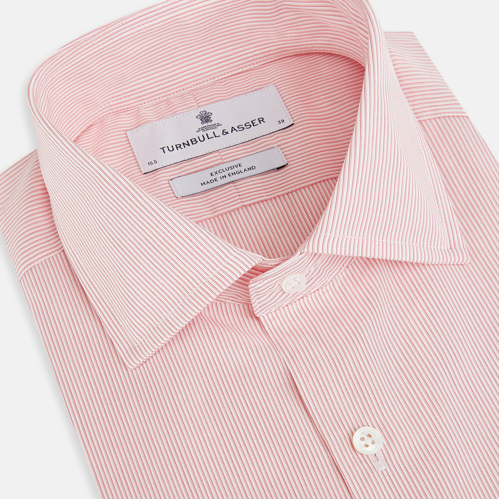 The Fine Striped Coral on White Tailored Fit Shirt in Cotton by Turnbull & Asser UK is a light pink long-sleeve button-up dress shirt with a collar, featuring subtle coral stripe detailing, displayed flat against a white background.