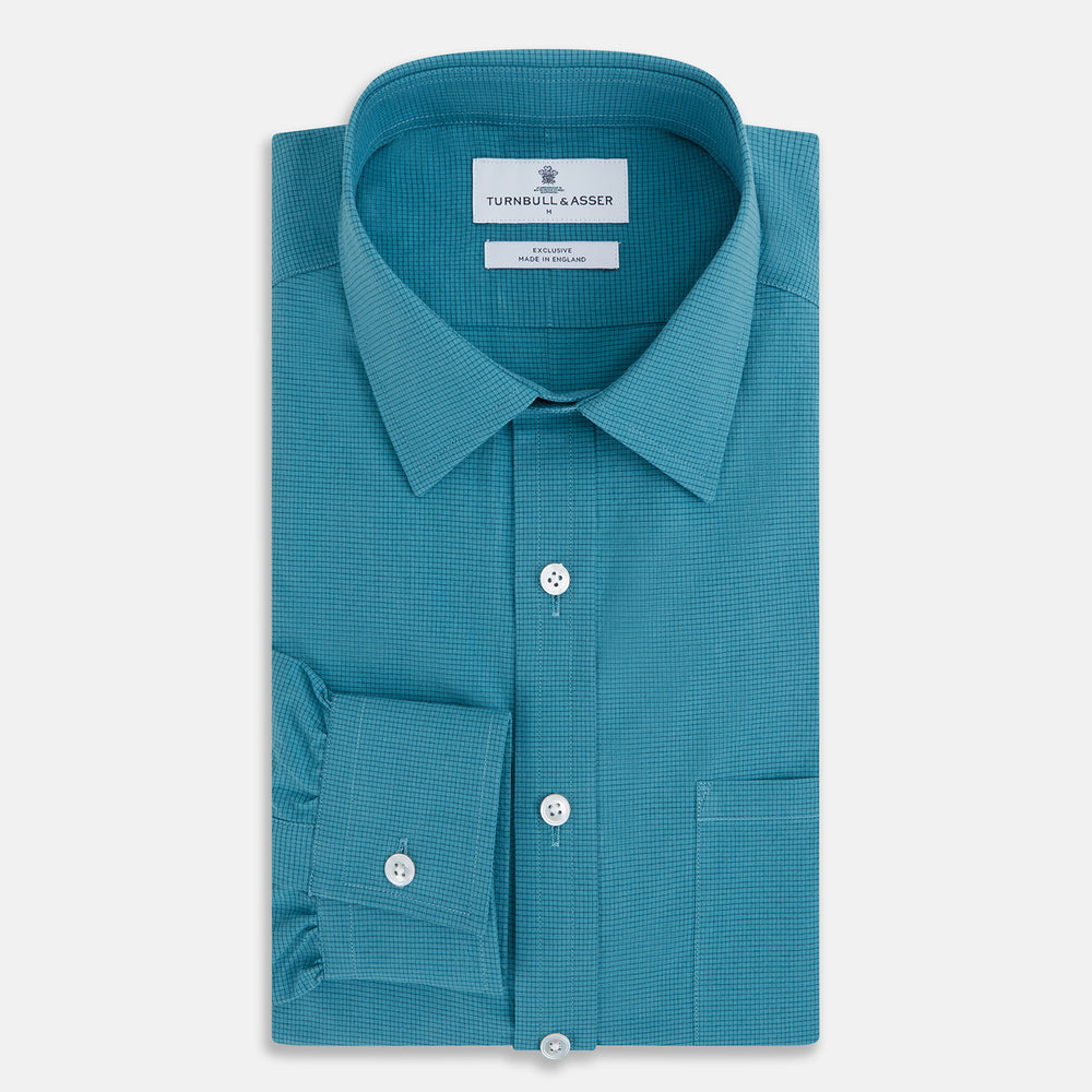Here’s a rewritten version using your product data: The Turnbull & Asser UK Fine Checked Turquoise Blue Weekend Fit Shirt in Cotton is a men’s long-sleeve button-up, featuring a chest pocket, white buttons, and a pointed collar, shown laid flat against a white background.