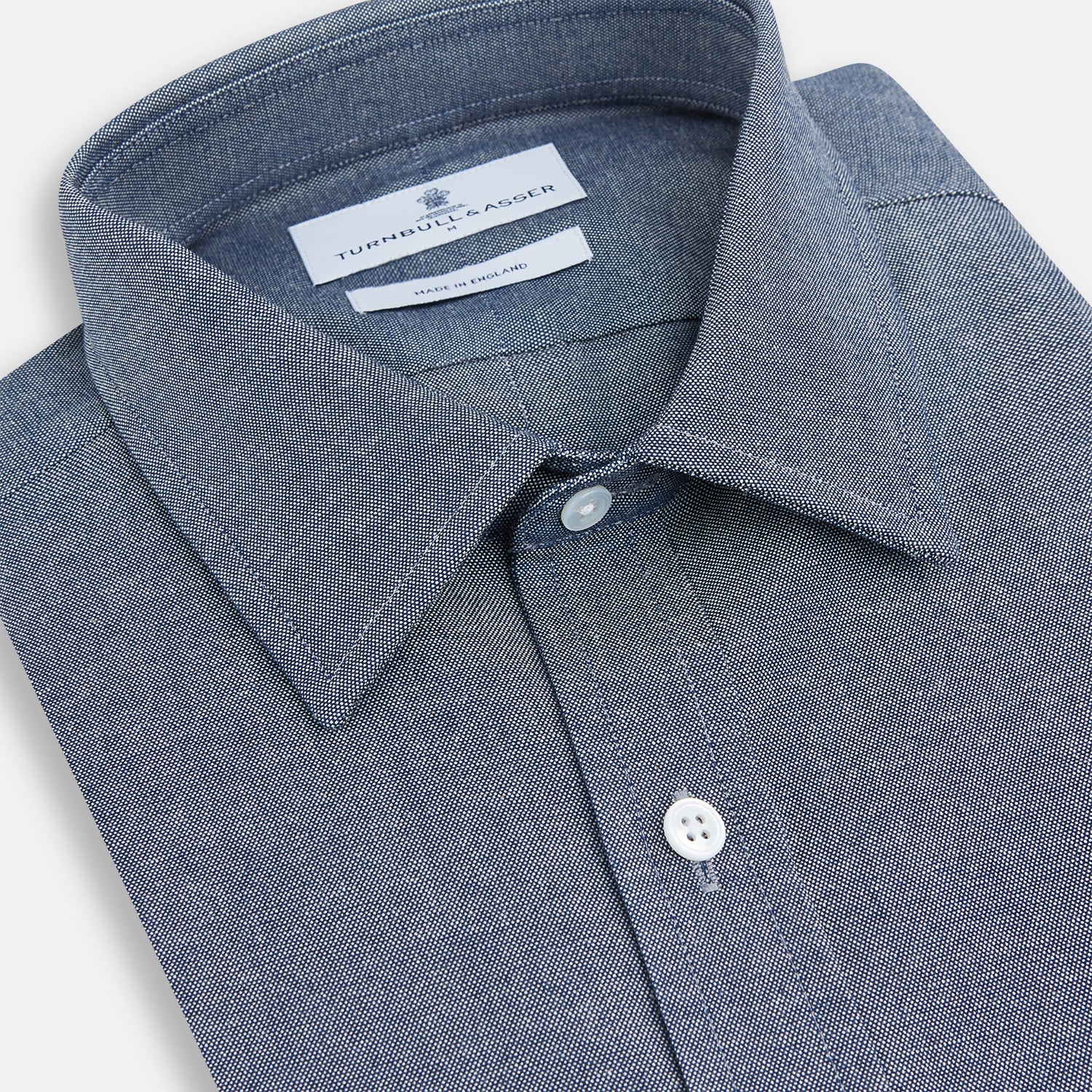 View 2 of product The Turnbull & Asser Steel Blue Richmond Shirt is a long-sleeved, button-up dress shirt with a Derby collar, single chest pocket, and buttoned cuffs—shown on a plain white background.