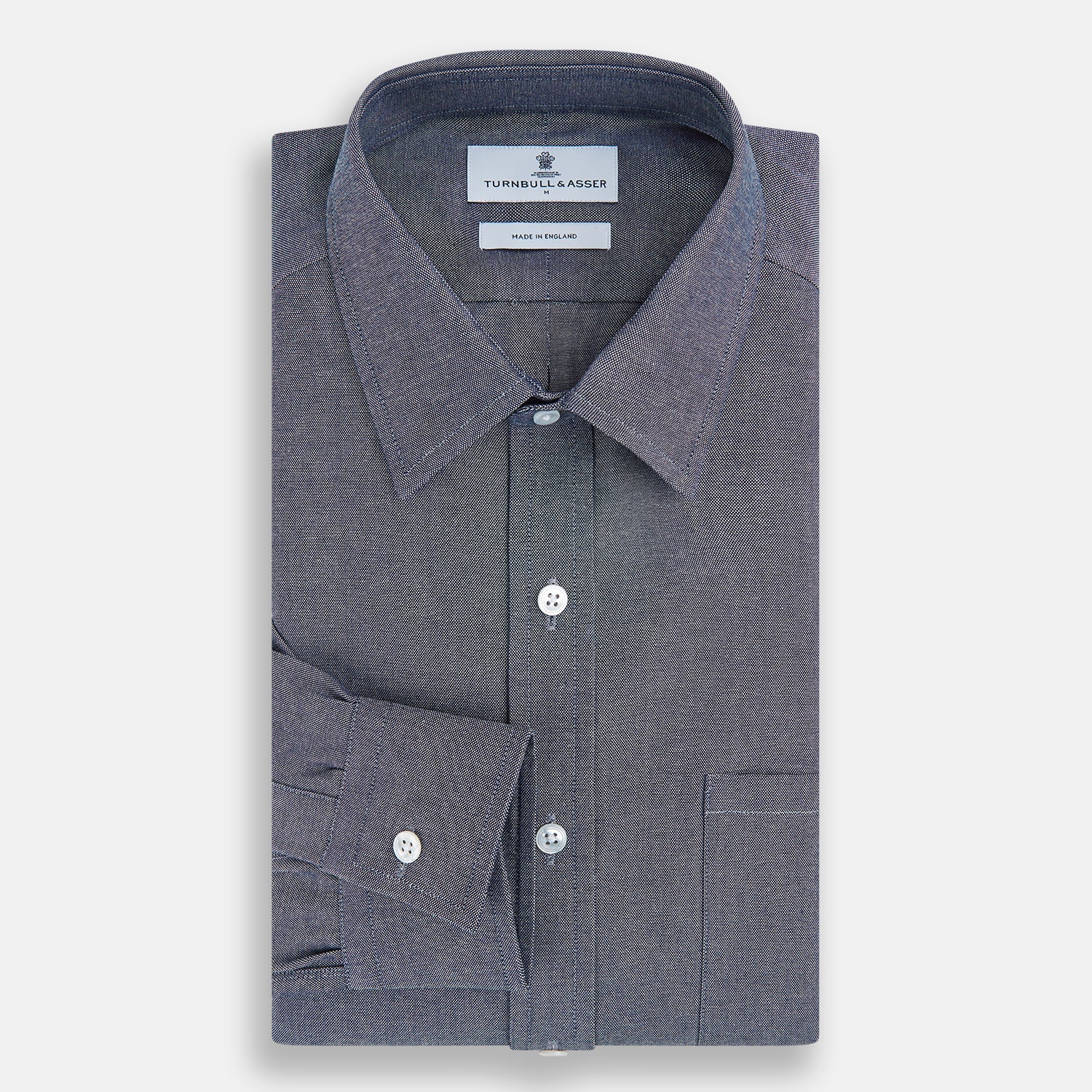 View 5 of product The Turnbull & Asser Steel Blue Richmond Shirt is a long-sleeved, button-up dress shirt with a Derby collar, single chest pocket, and buttoned cuffs—shown on a plain white background.