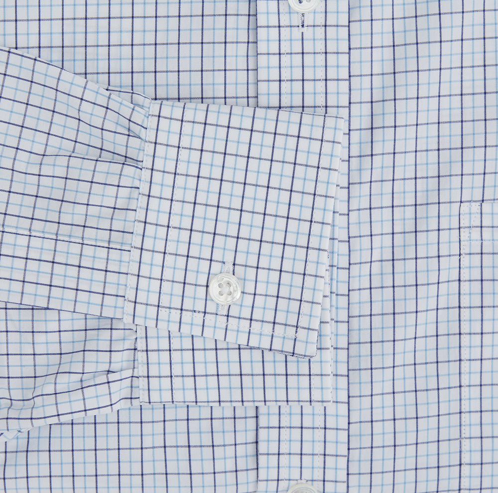 The Turnbull & Asser Blue Double Graph Check Richmond Shirt features a light blue and white check pattern, front pocket, Derby collar, buttoned cuffs, and long sleeves, shown laid flat on a white background.