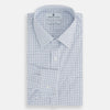 View 4 of product The Turnbull & Asser Blue Double Graph Check Richmond Shirt features a light blue and white check pattern, front pocket, Derby collar, buttoned cuffs, and long sleeves, shown laid flat on a white background.