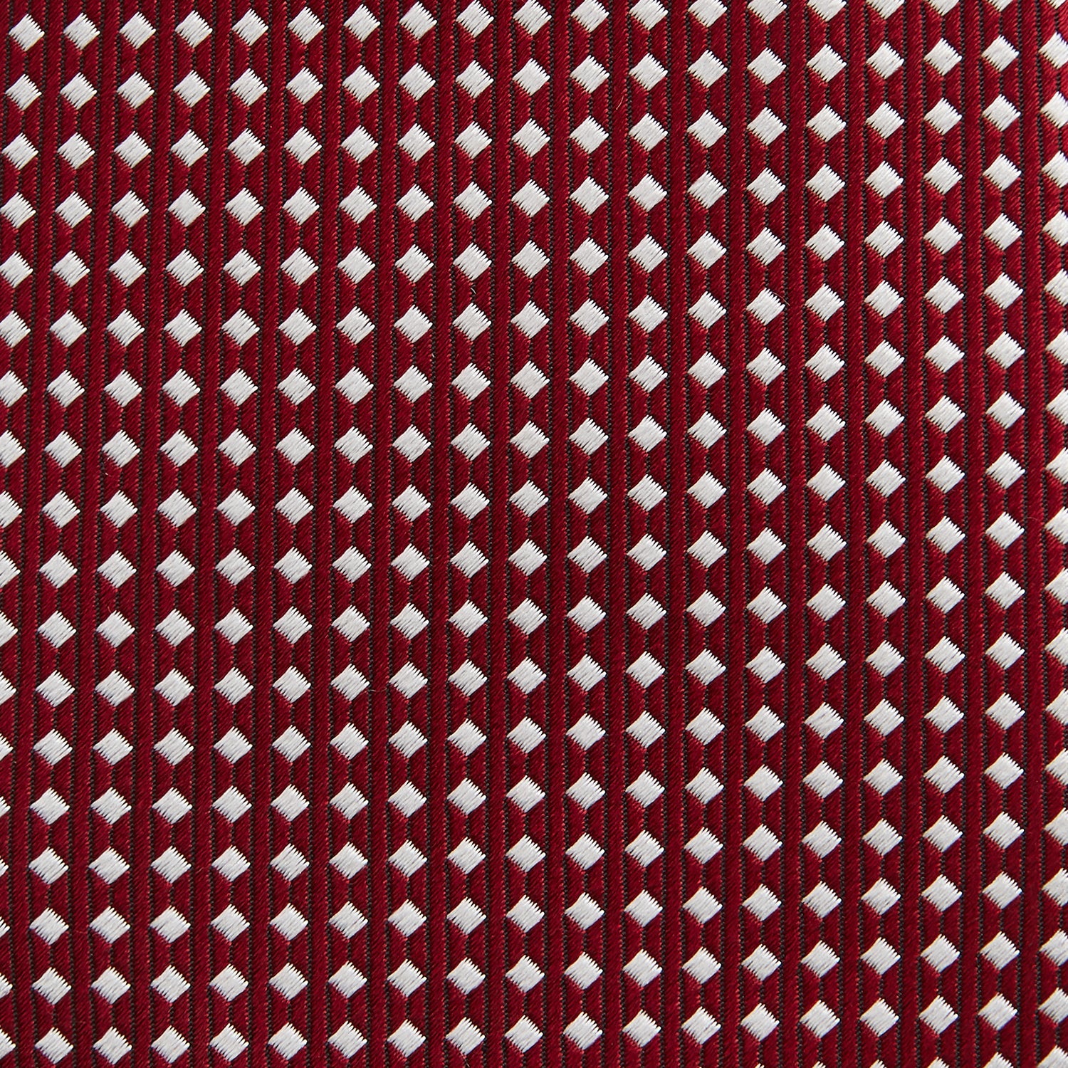 View 3 of product The Turnbull & Asser Slim Burgundy and White Diamond Silk Tie, shown rolled on a white background, features a repeating pattern of small white diamonds—an ideal accessory to complement any office shirt.