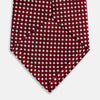 View 4 of product The Turnbull & Asser Slim Burgundy and White Diamond Silk Tie, shown rolled on a white background, features a repeating pattern of small white diamonds—an ideal accessory to complement any office shirt.