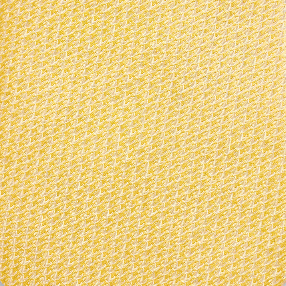 The Turnbull & Asser Yellow Lace Silk Tie, featuring a light yellow hue and subtle texture, is neatly rolled and displayed on a plain white background.
