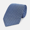 View 1 of product The Turnbull & Asser Navy and Blue Micro Dot Silk Tie is shown rolled up, featuring a steel blue color with small navy blue dots, on a plain white background.