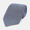 View 1 of product The Turnbull & Asser Navy and Pale Blue Micro Dot Silk Tie features a pattern of small, evenly spaced dots and is elegantly rolled on a plain white background.