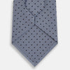 View 3 of product The Turnbull & Asser Navy and Pale Blue Micro Dot Silk Tie features a pattern of small, evenly spaced dots and is elegantly rolled on a plain white background.