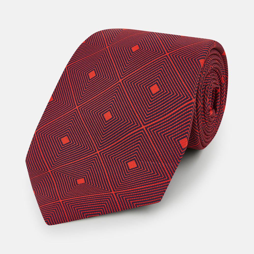 A rolled Tulip Red Concentric Diamond Printed Silk Tie in red silk featuring a dark blue concentric diamond pattern.