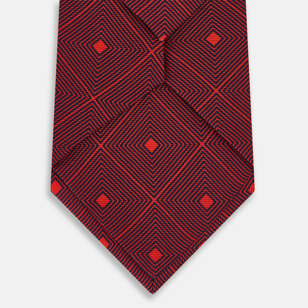 View 3 of product A rolled Tulip Red Concentric Diamond Printed Silk Tie in red silk featuring a dark blue concentric diamond pattern.
