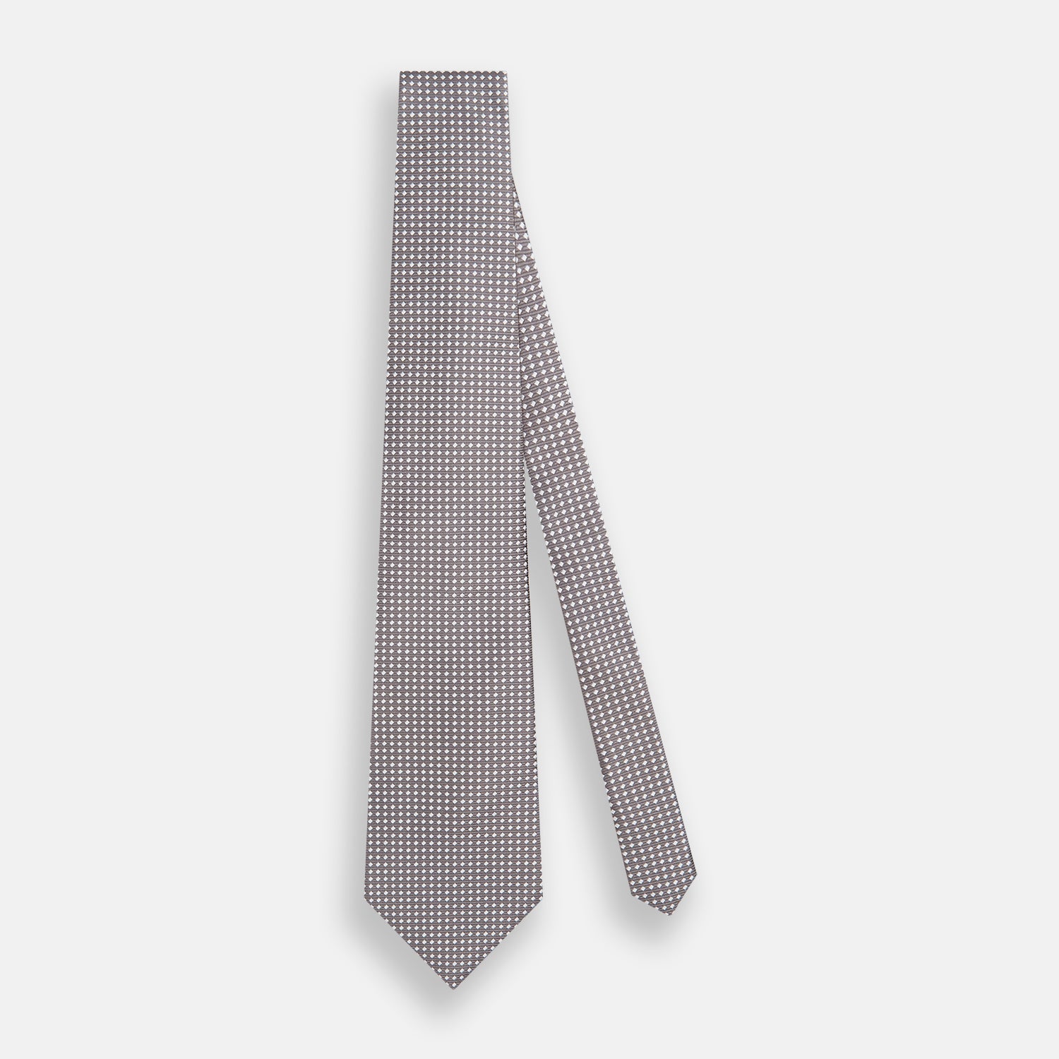 View 2 of product The Turnbull & Asser Grey and White Diamond Silk Tie features a refined geometric pattern, combining silver triangles on a white background for an elegant look.