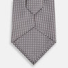 View 3 of product The Turnbull & Asser Grey and White Diamond Silk Tie features a refined geometric pattern, combining silver triangles on a white background for an elegant look.