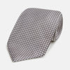 View 1 of product The Turnbull & Asser Grey and White Diamond Silk Tie features a refined geometric pattern, combining silver triangles on a white background for an elegant look.
