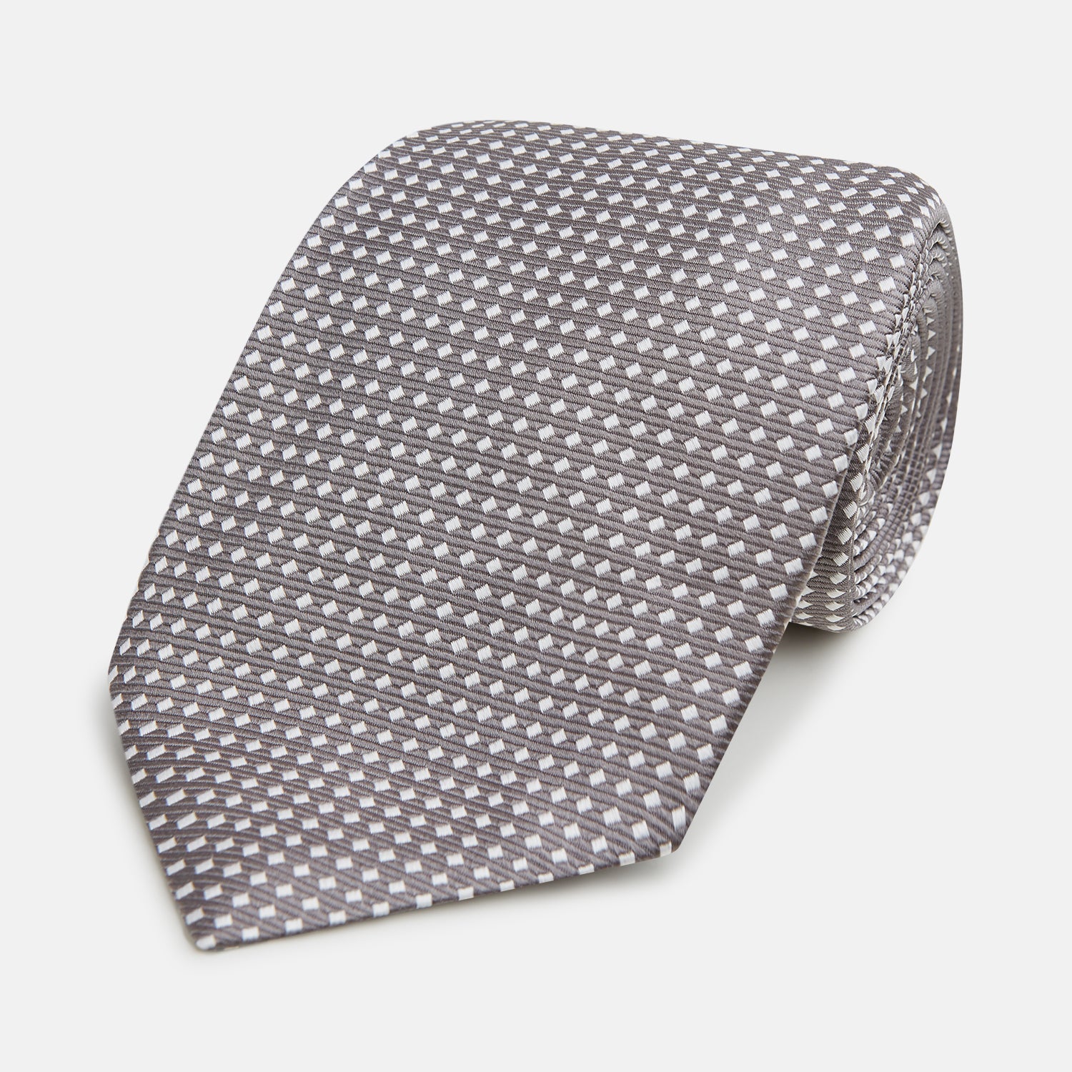 View 1 of product The Turnbull & Asser Grey and White Diamond Silk Tie features a refined geometric pattern, combining silver triangles on a white background for an elegant look.