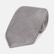 The Turnbull & Asser Grey and White Diamond Silk Tie features a refined geometric pattern, combining silver triangles on a white background for an elegant look.