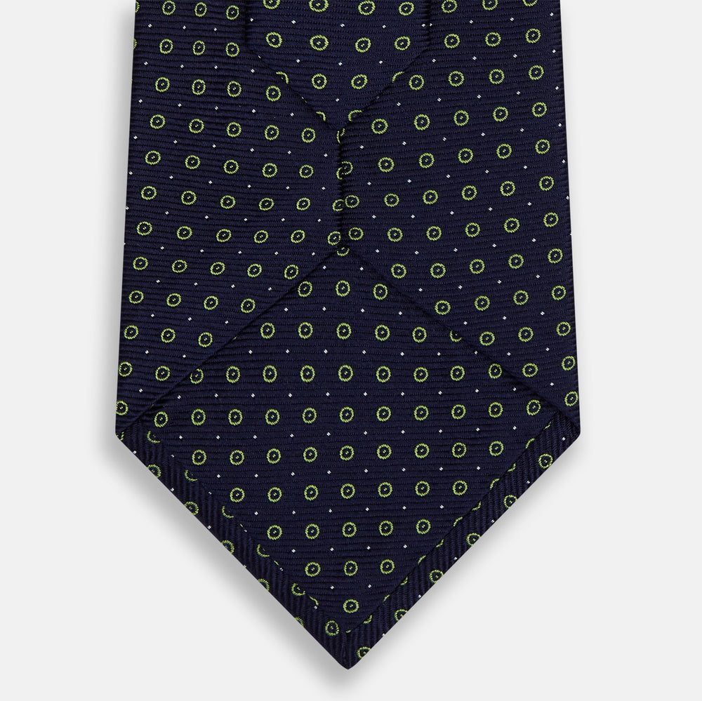 The Turnbull & Asser Navy and Light Green Circle Silk Tie features a navy base with small light green circular patterns, crafted from fine silk.
