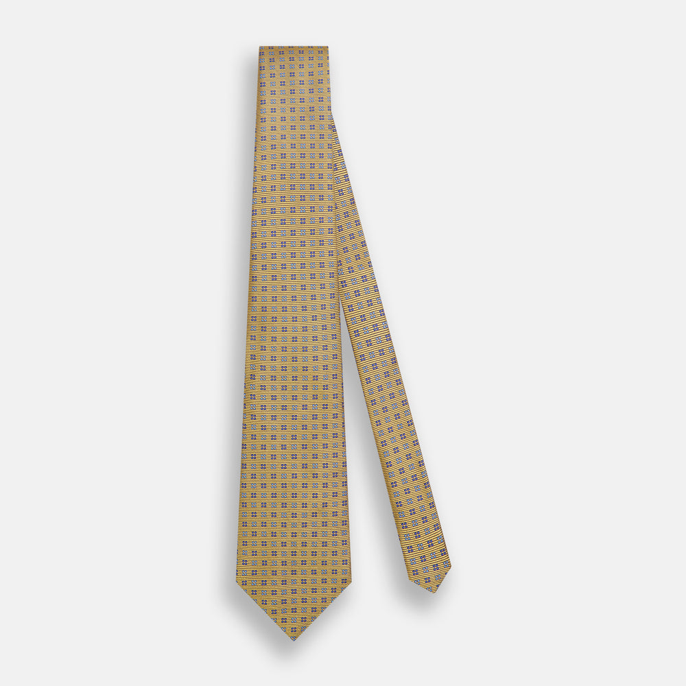 The Turnbull & Asser Blue and Gold Multi Dot Silk Tie features blue and gold dots in neat rows, presented rolled up on a white background.