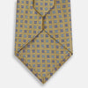 View 3 of product The Turnbull & Asser Blue and Gold Multi Dot Silk Tie features blue and gold dots in neat rows, presented rolled up on a white background.