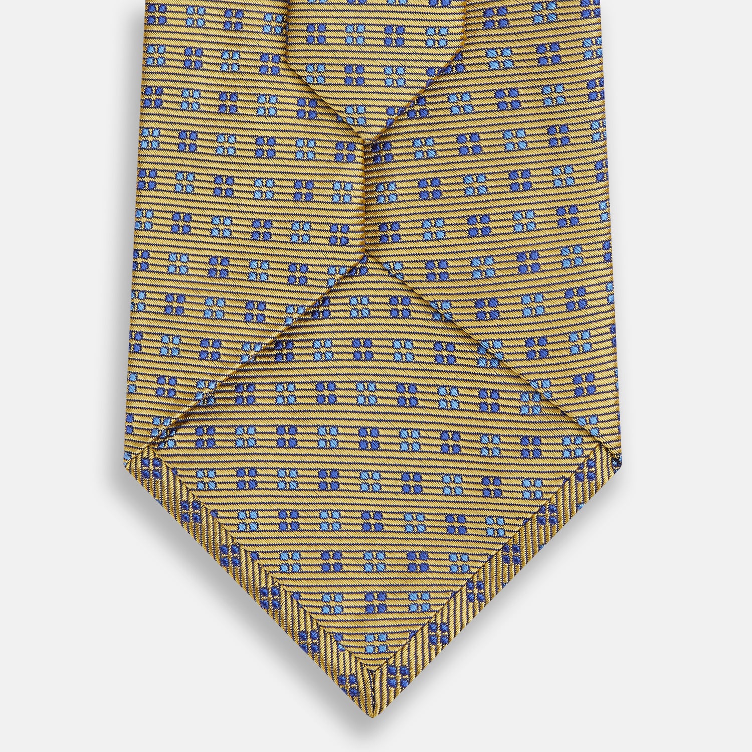 View 3 of product The Turnbull & Asser Blue and Gold Multi Dot Silk Tie features blue and gold dots in neat rows, presented rolled up on a white background.