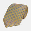 View 1 of product The Turnbull & Asser Blue and Gold Multi Dot Silk Tie features blue and gold dots in neat rows, presented rolled up on a white background.