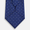 View 3 of product The Turnbull & Asser Blue and Brown Multi Dot Silk Tie, shown rolled up on a plain white background, features an elegant design with small white and gray dots arranged in squares.
