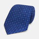 The Turnbull & Asser Blue Multi Dot Silk Tie features a rolled-up blue design with small light blue dots, offering an elegant, refined accent to office attire.