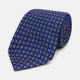 The Turnbull & Asser Blue and Yellow Multi Dot Silk Tie features a geometric yellow and white pattern, ideal for modern office wear. The elegant silk tie is showcased rolled up on a plain white background.