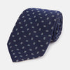 View 1 of product The Turnbull & Asser Navy Micro Rectangle Silk Tie, featuring a repeating light blue and white rectangle pattern, is shown rolled up on a plain white background.