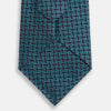 View 3 of product The Turnbull & Asser Turquoise Geometric Silk Tie features interlocking blue and teal cubes for a 3D effect, offering British elegance. Shown rolled up on a plain white background.