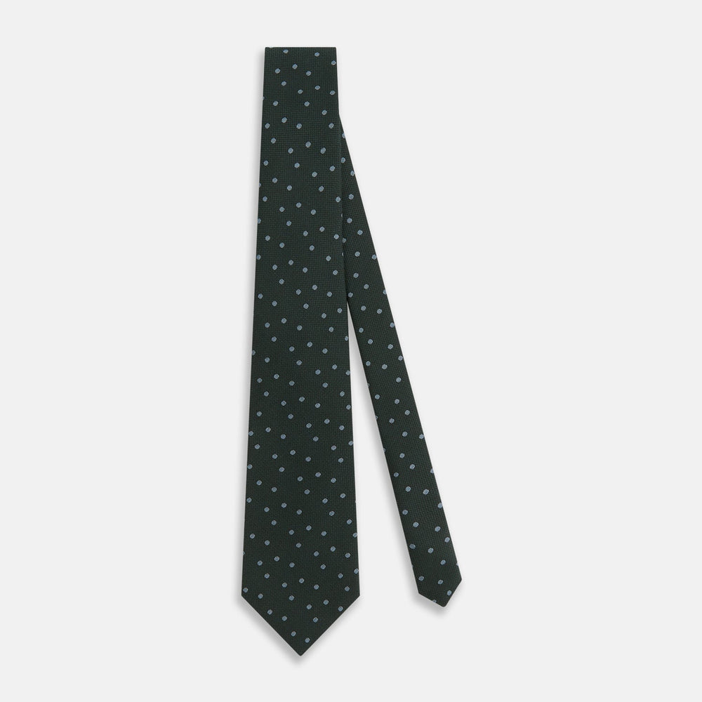 The Turnbull & Asser Pale Blue and Green Micro Dot Silk Blend Tie, shown rolled on a white background, is ideal for complementing your favorite shirts.