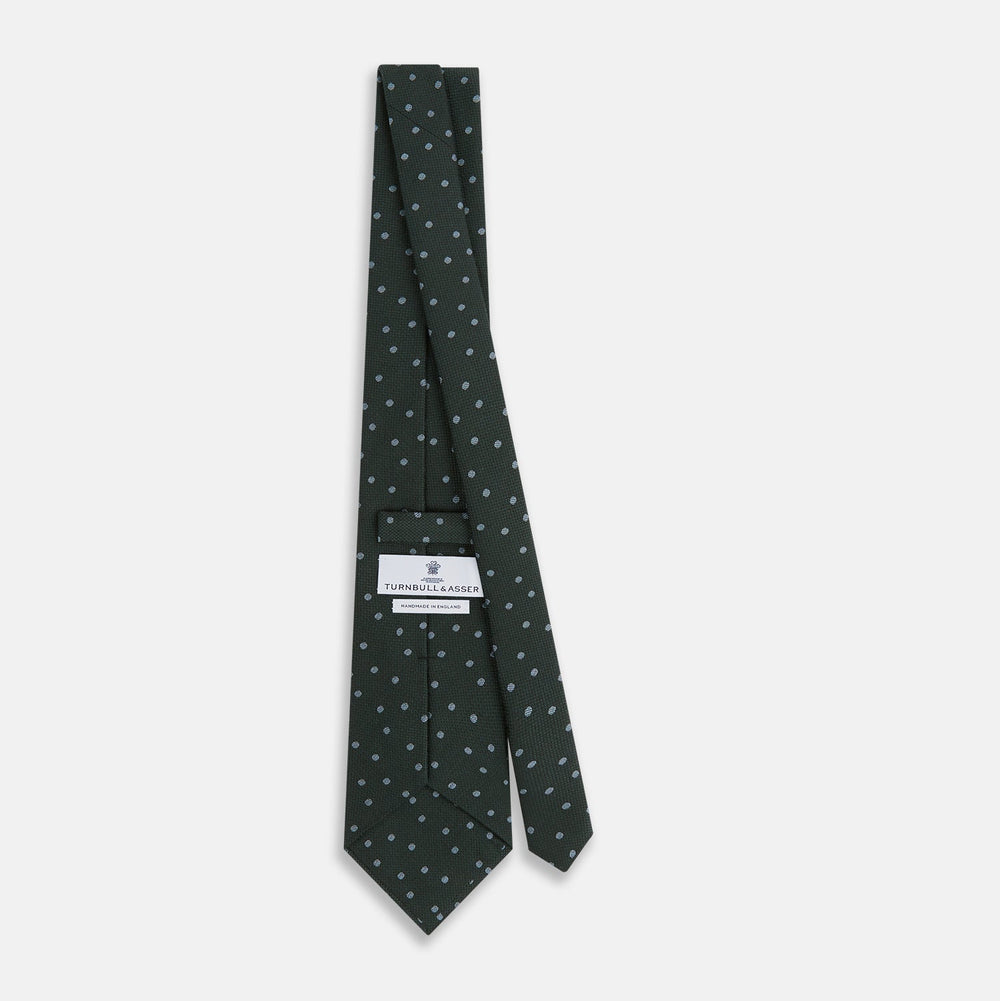 The Turnbull & Asser Pale Blue and Green Micro Dot Silk Blend Tie, shown rolled on a white background, is ideal for complementing your favorite shirts.