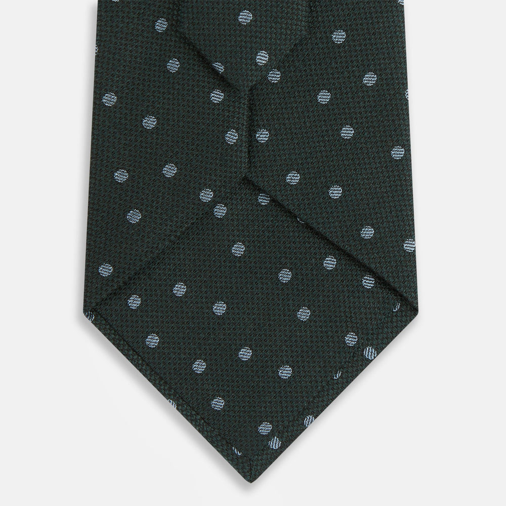 The Turnbull & Asser Pale Blue and Green Micro Dot Silk Blend Tie, shown rolled on a white background, is ideal for complementing your favorite shirts.