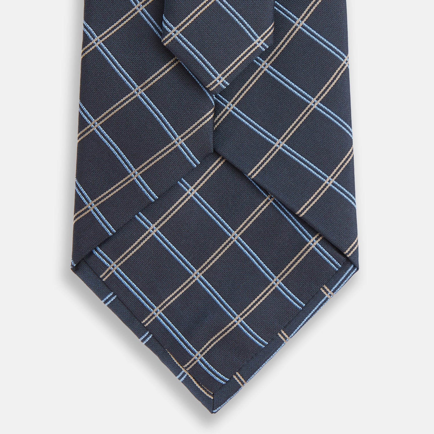 View 3 of product The Turnbull & Asser Navy Fine Double Check Silk Tie, featuring a refined navy, light blue, and tan plaid, is neatly rolled on a white background—an ideal accessory to complement any Turnbull & Asser shirt.