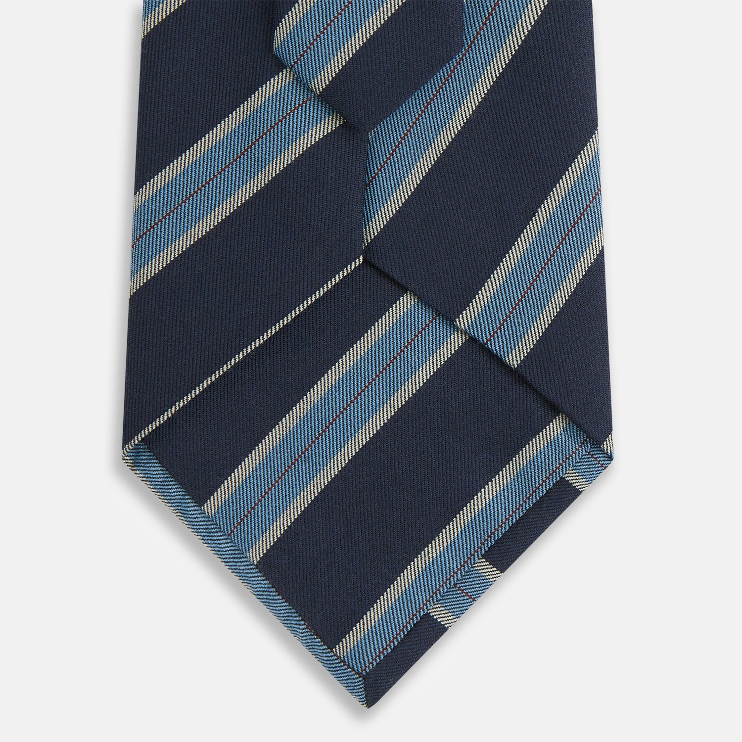View 3 of product The Turnbull & Asser Blue Multi Stripe Silk Blend Tie features navy, light blue, and silver diagonal stripes and is displayed rolled up on a white background. An ideal pairing with Turnbull & Asser shirts.