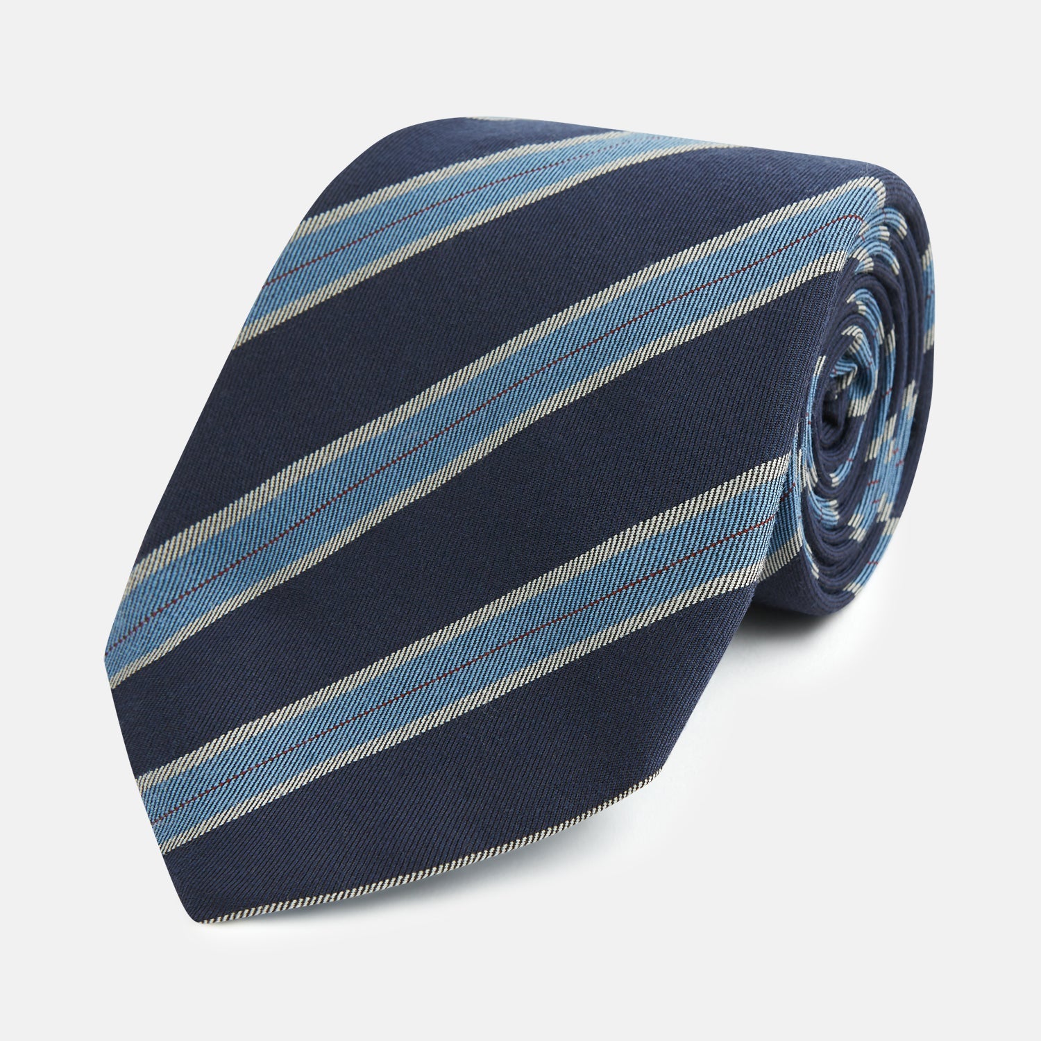 View 1 of product The Turnbull & Asser Blue Multi Stripe Silk Blend Tie features navy, light blue, and silver diagonal stripes and is displayed rolled up on a white background. An ideal pairing with Turnbull & Asser shirts.