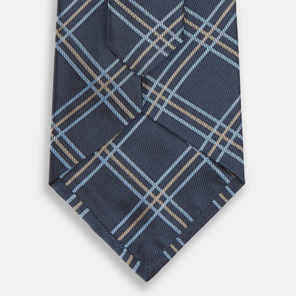 The Turnbull & Asser Navy Triple Check Silk Tie features a light blue and white plaid pattern—an essential accessory for the modern gentleman and a perfect complement to any Turnbull & Asser shirt.